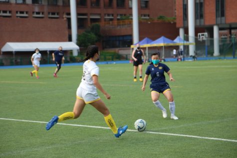 Varsity soccer player Kayo U. (22) defends her teammate in a team scrimmage. 
and picture credit: [Victoria Hsu/The Blue and Gold]