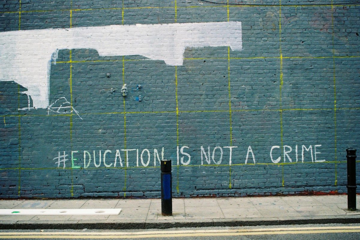 Graffiti on a brick wall arguing that education is not a crime. [Photo courtesy of Aleksandro Jarocka]