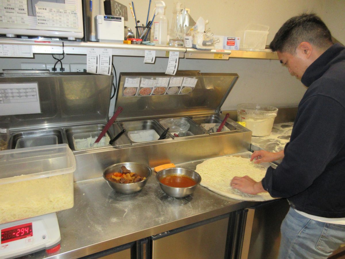 Eric Nam working on a pizza in The Slice Shop [NAOMI LEE/THE BLUE & GOLD]